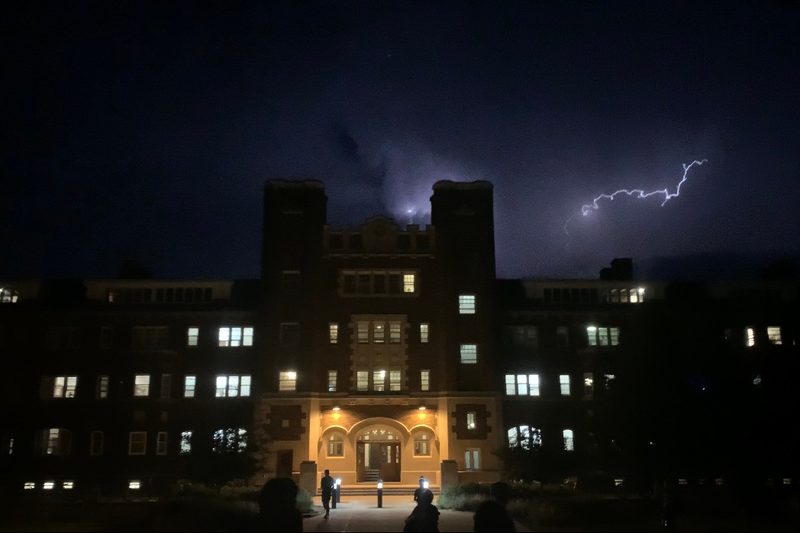 A couple bolts of lightning strike over the entrance to Burton Hall