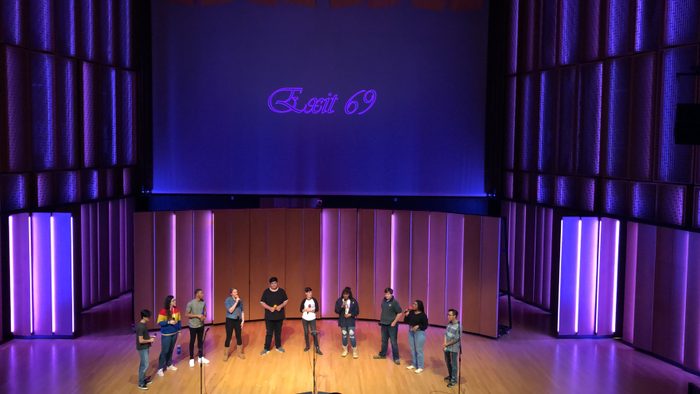 Indoor, 10 students standing on stage and performing a song