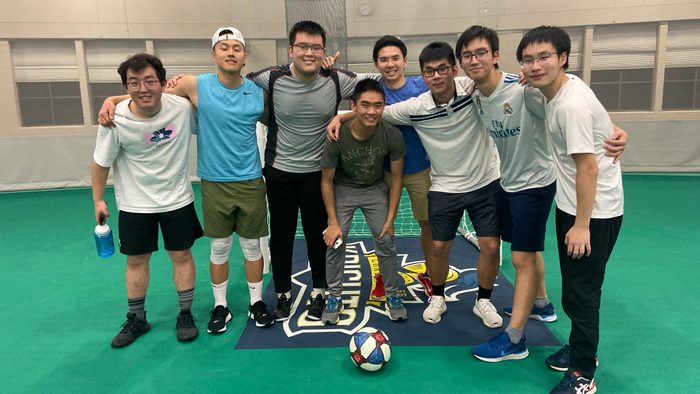 Picture of 8 male young adults in an indoor soccer field
