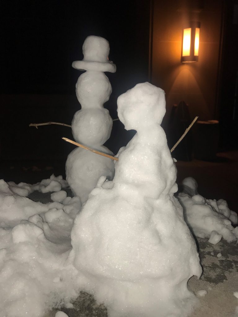 There are little snow people, and one has a top hat
