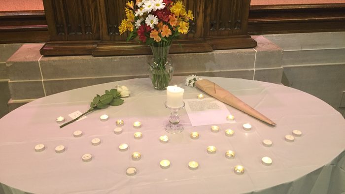A white table with flowers and candles