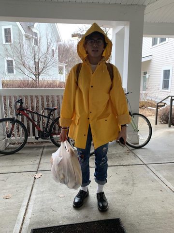 guy in a raincoat with groceries