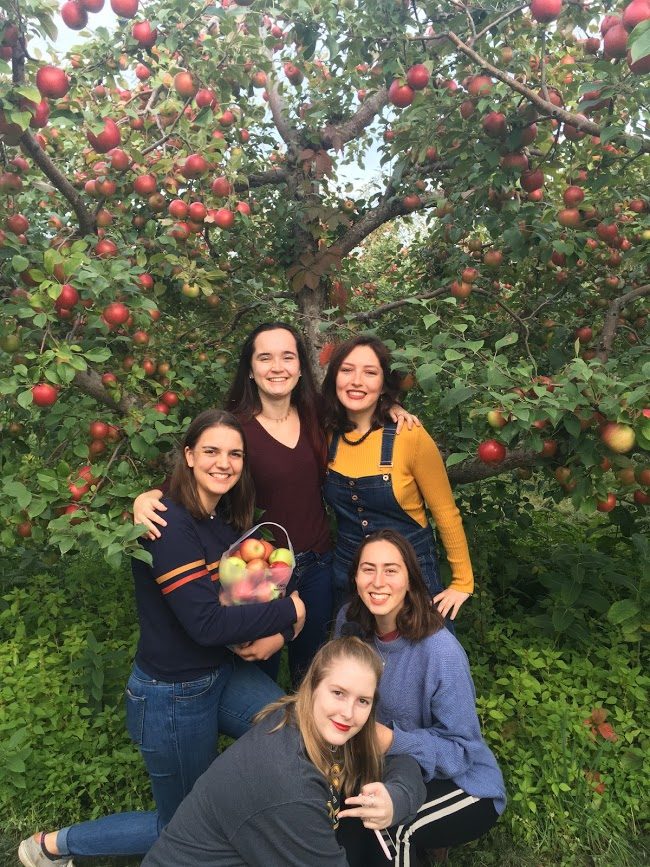 McKenna and friends in front of apple trees