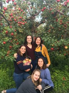 McKenna and friends in front of apple trees