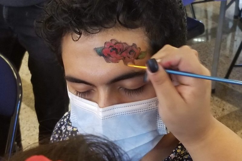 Red Roses Being Painted on a Forehead