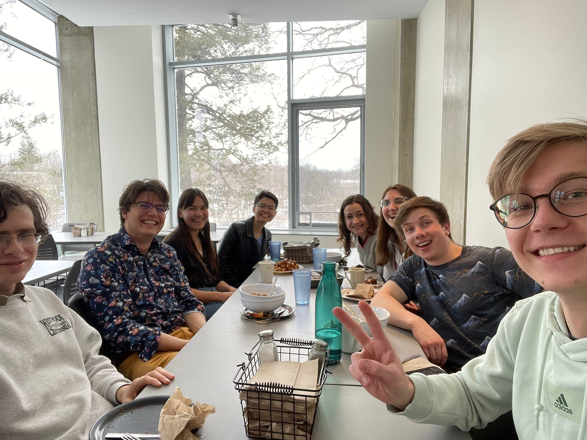 Student sit at a table and smile