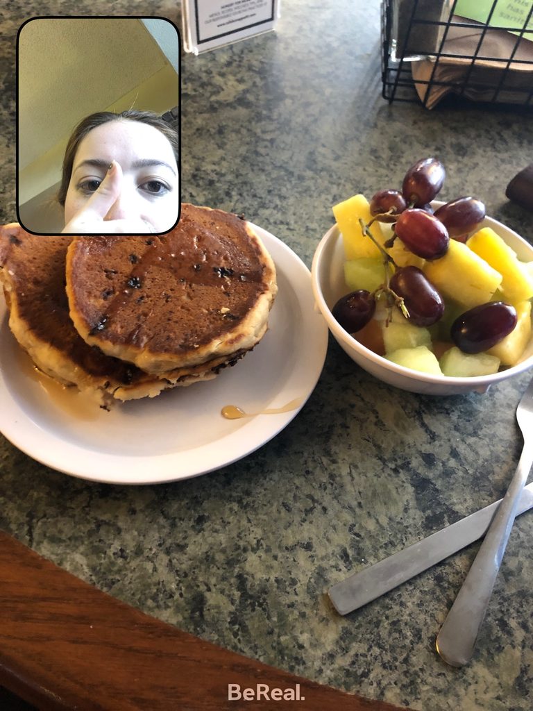 Quinn shows off her breakfast of pancakes and fruit