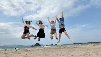 students jumping on a beach
