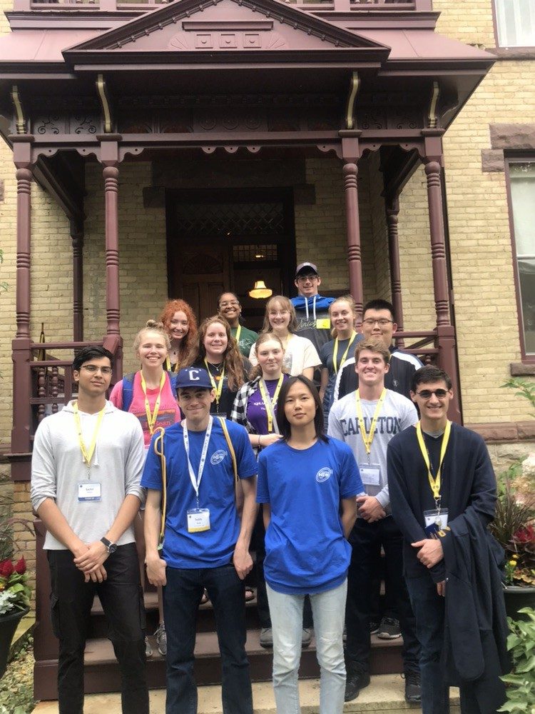 A new student week group standing outside nutting house