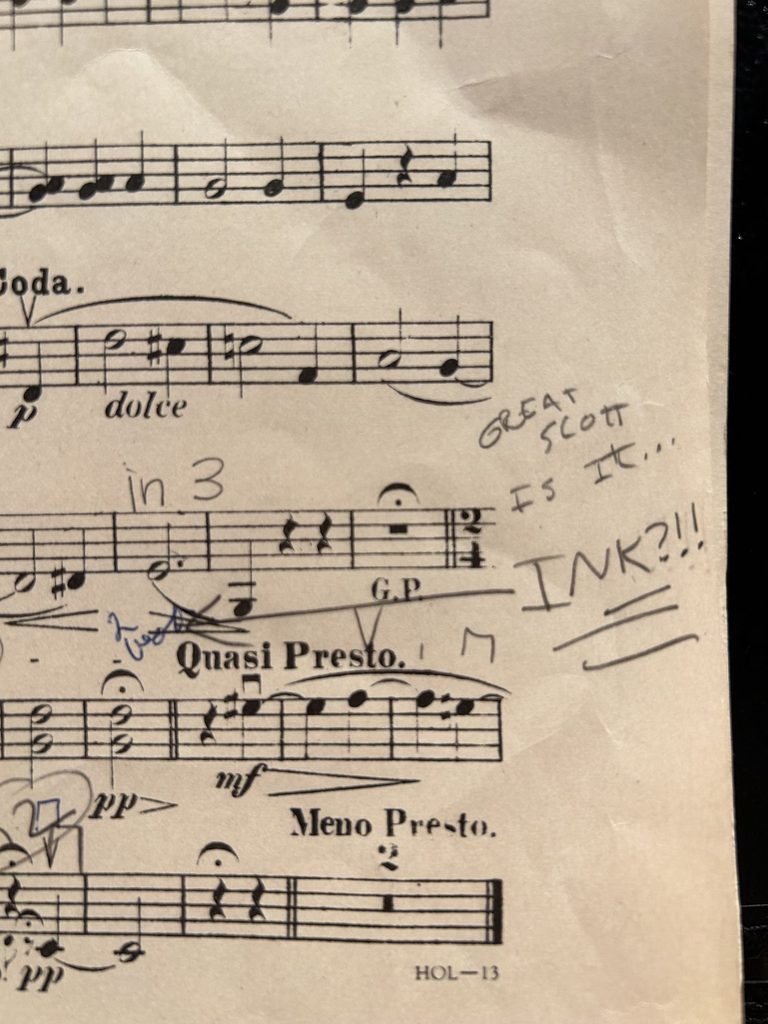 Photo of sheet music with ink on it