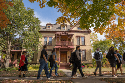 tour group walks in front of president's house in fall