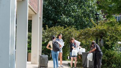 Students and families empty a cart on move-in day.