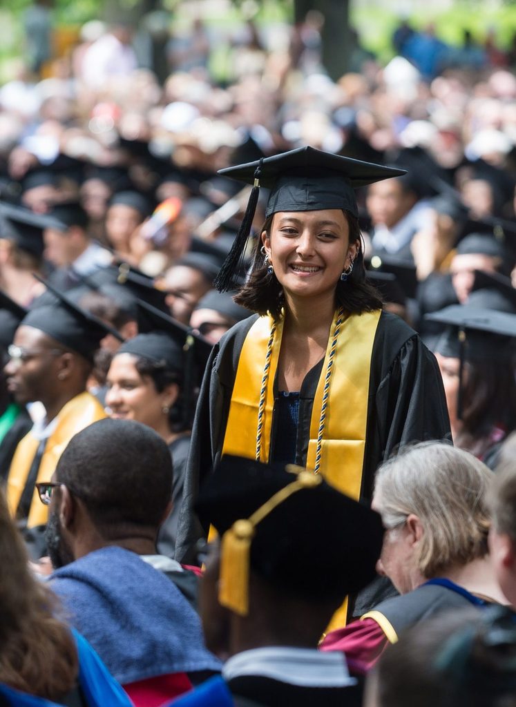 graduating student smiling in the crowd