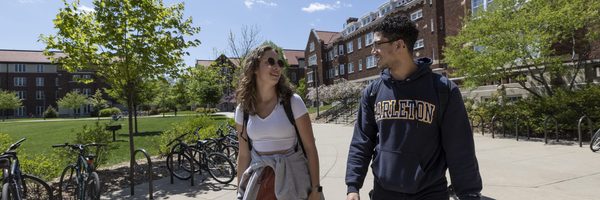 students walking past a residence hall in spring