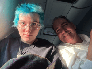 A selfie of two people sitting on an airplane.