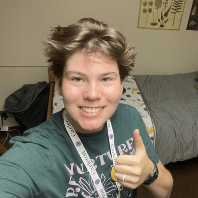 Felix stands in his dorm room, giving a thumbs-up