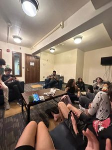 Defne and other students sit around a coffee table in one of the dorm buildings