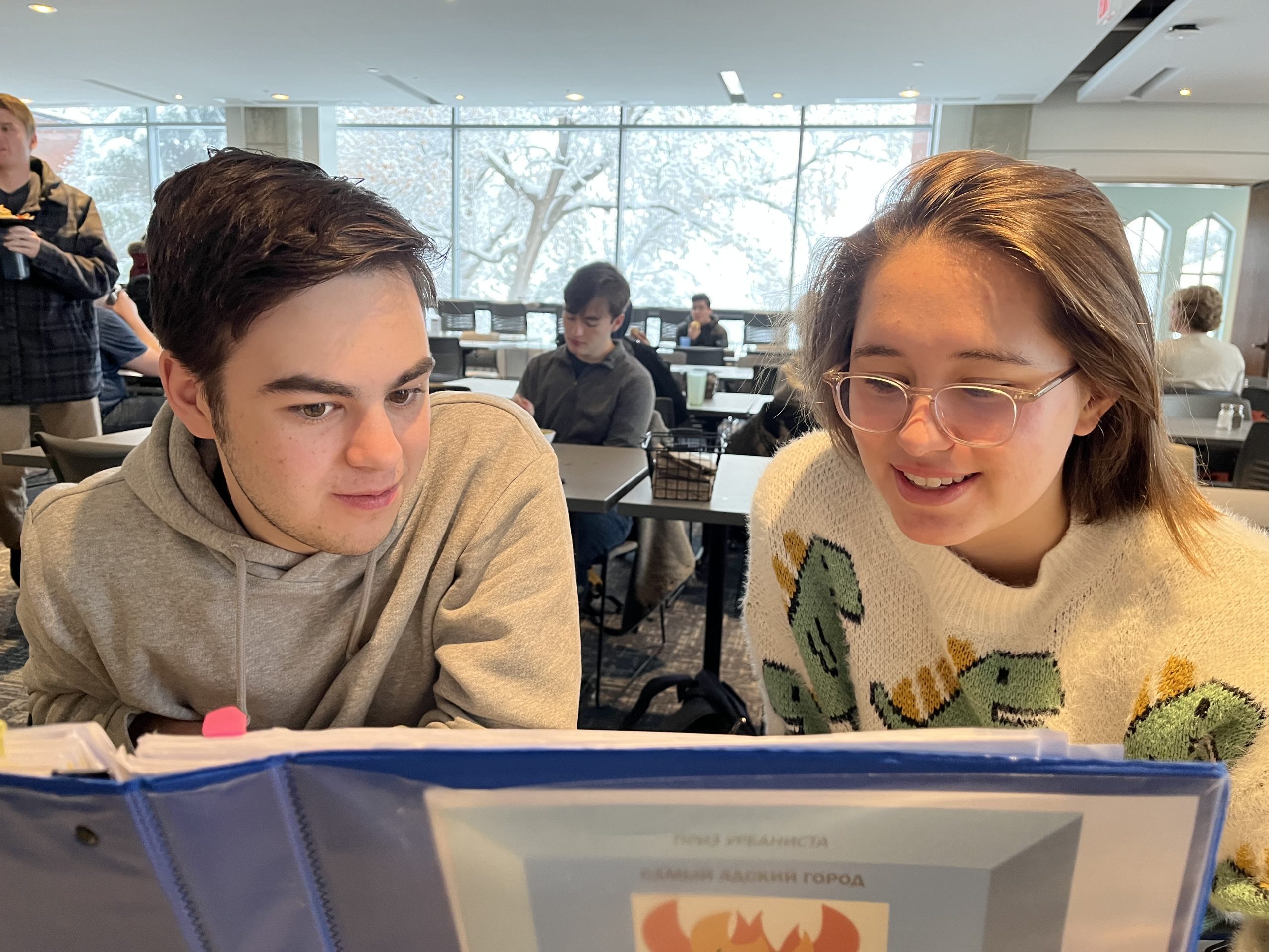 Two students study from their Russian textbook