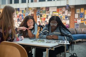 Three students study at a table in Anderson Hall