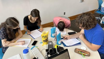 Four students sitting at a round table and studying