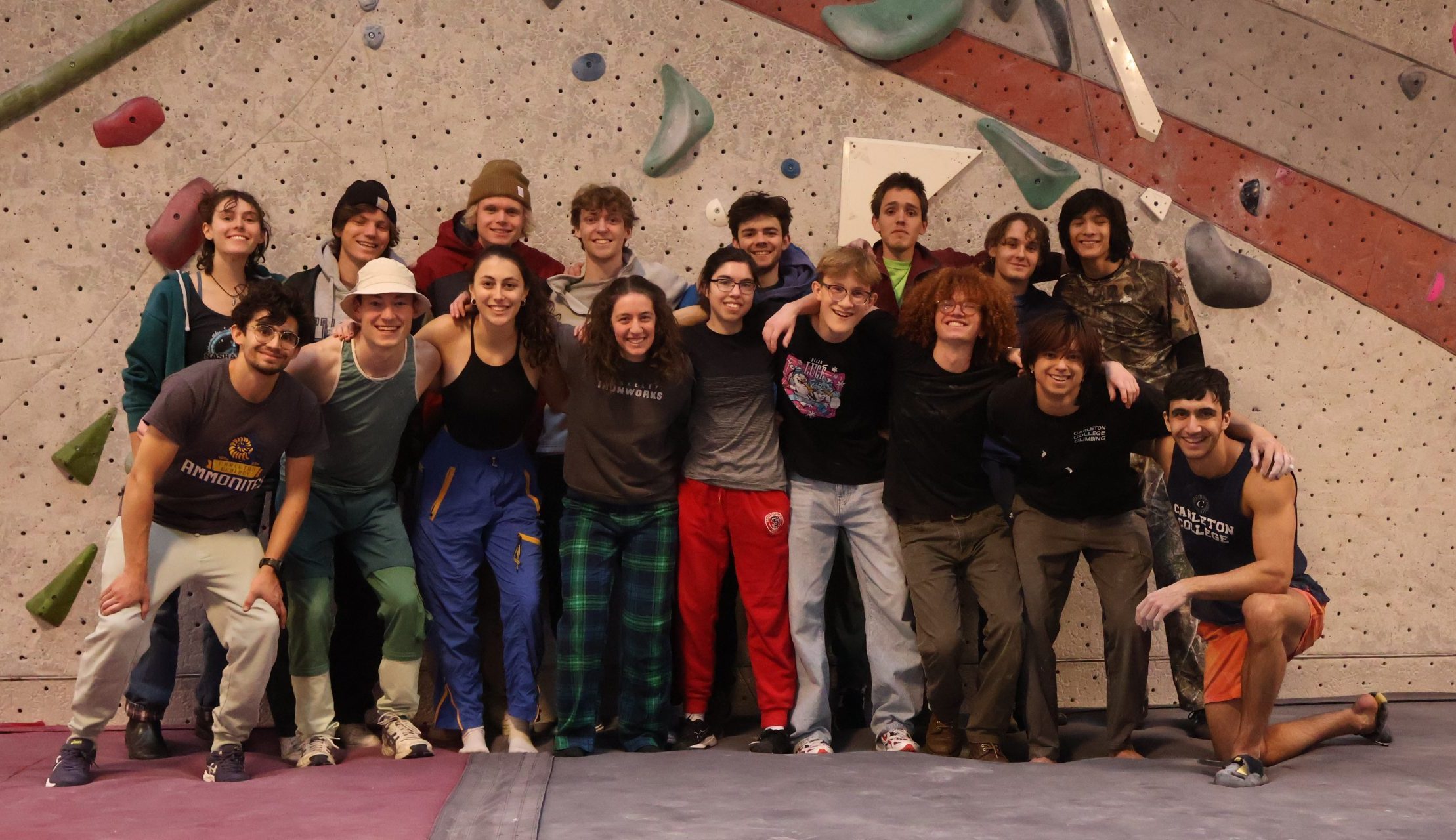 students standing in front of rock climbing wall