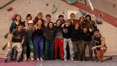 students standing in front of rock climbing wall
