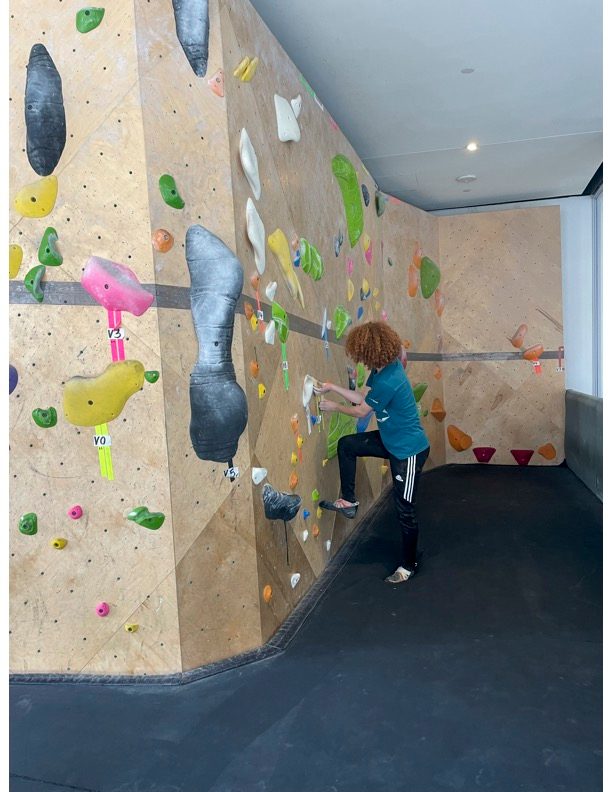 george standing holding the rock climbing wall