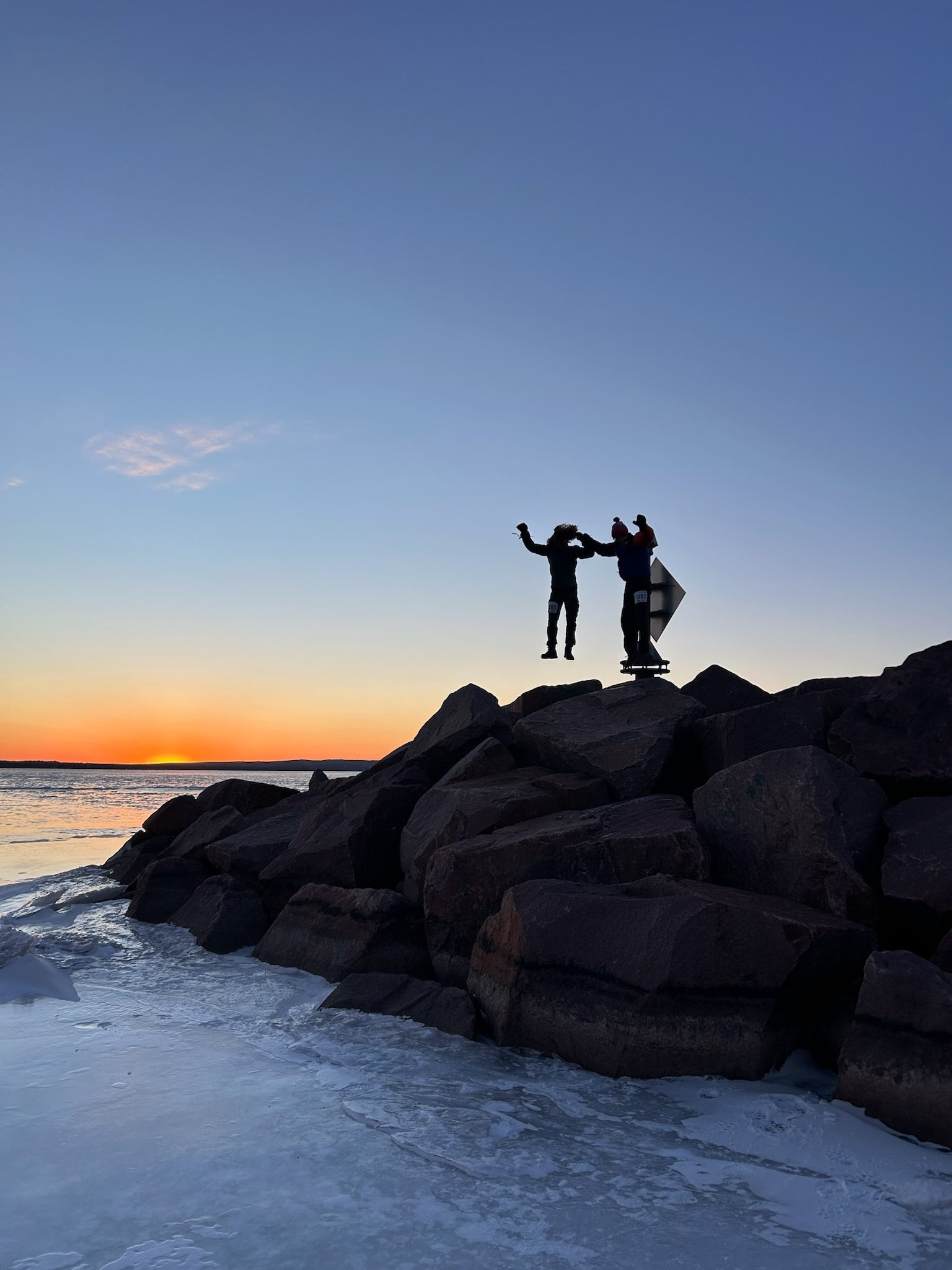 two people jumping in the sunset