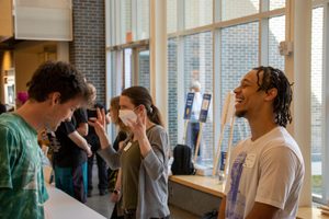 Two students talk at a booth at an admitted student day