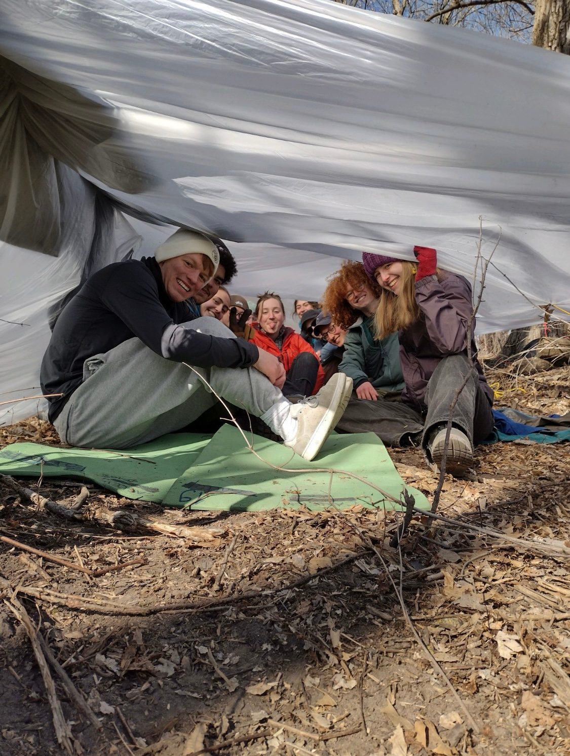 people posing under a makeshift tent