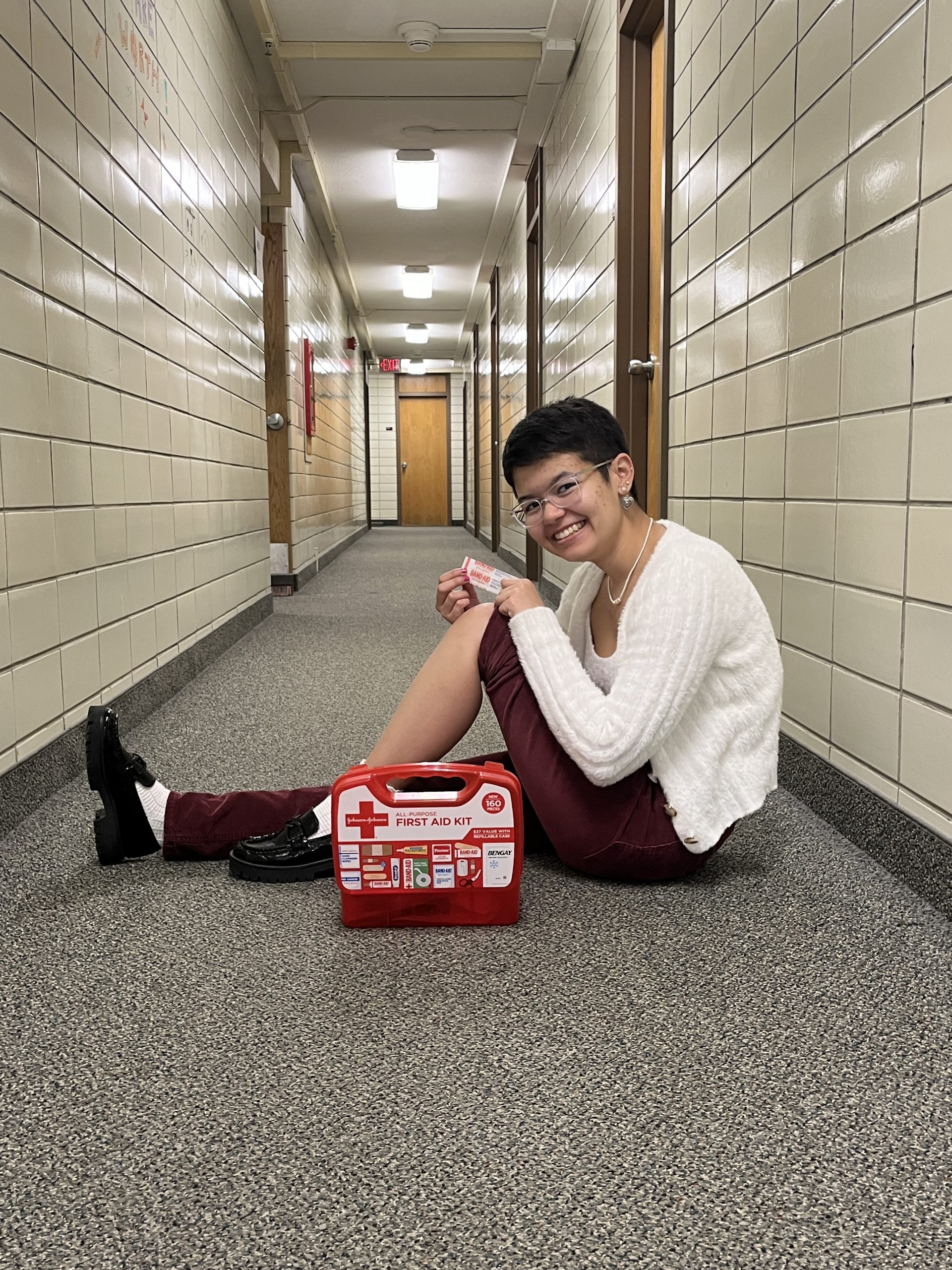 Lexi sits in her dorm hallway with a first aid kit