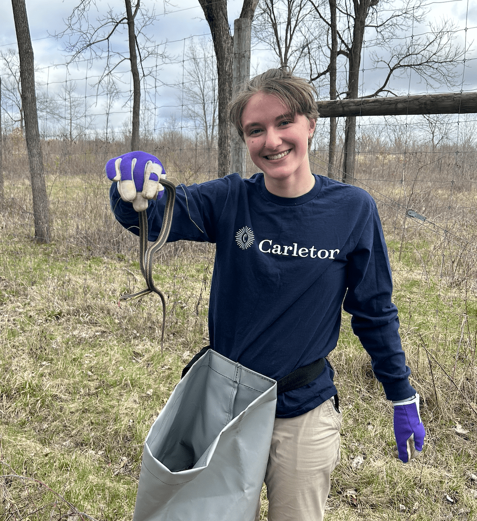 A Carleton student poses with a snake in the Arb
