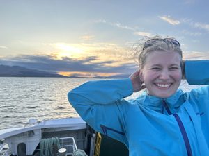 women smiles with sunset in the background