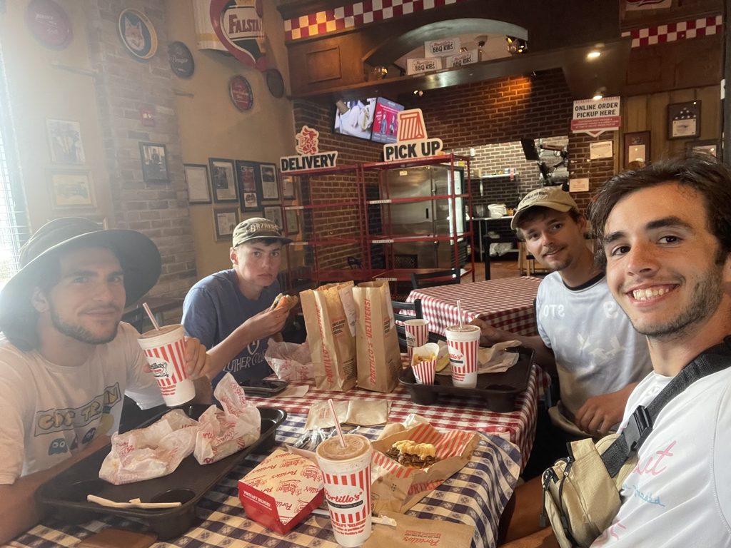 four boys in a restaurant smile at the camera