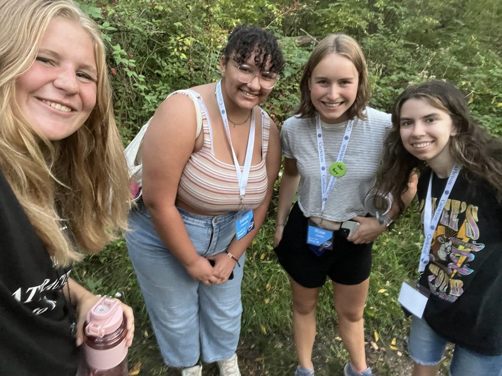 Four people outside smiling at the camera