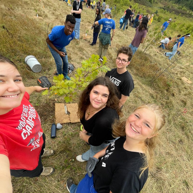 Five people outside smiling at a camera