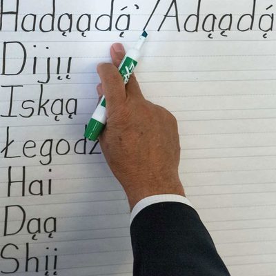 A hand points to Apache vocabulary on a piece of paper