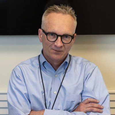 Eric Wieffering standing against a wall with his arms crossed