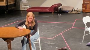 A girl sitting at a table on a stage