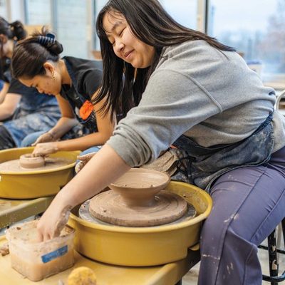 students creating bowls on a potter's wheel