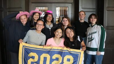 Students posing for a photo while holding a 2028 banner