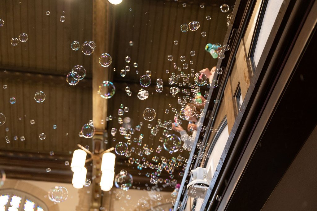 bubbles blown by students stream over the chapel balcony