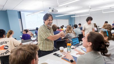 a professor working with 2 students during class