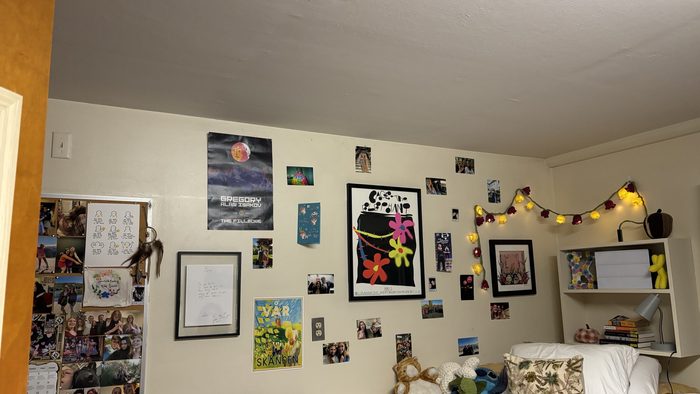 A dorm room decorated with posters and lights