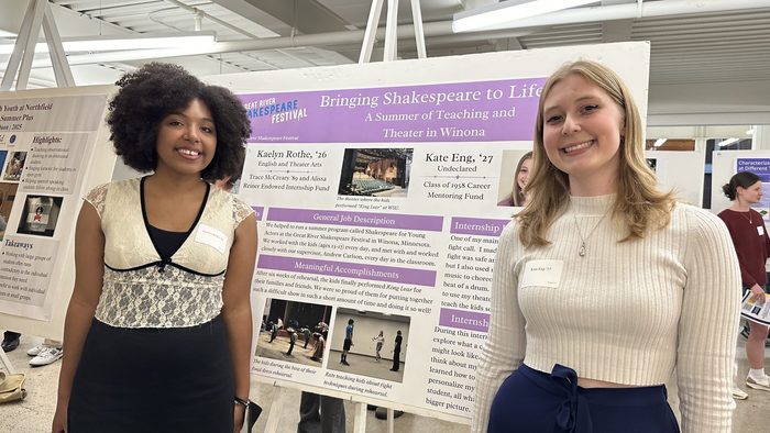 Two girls in front of their poster presentation