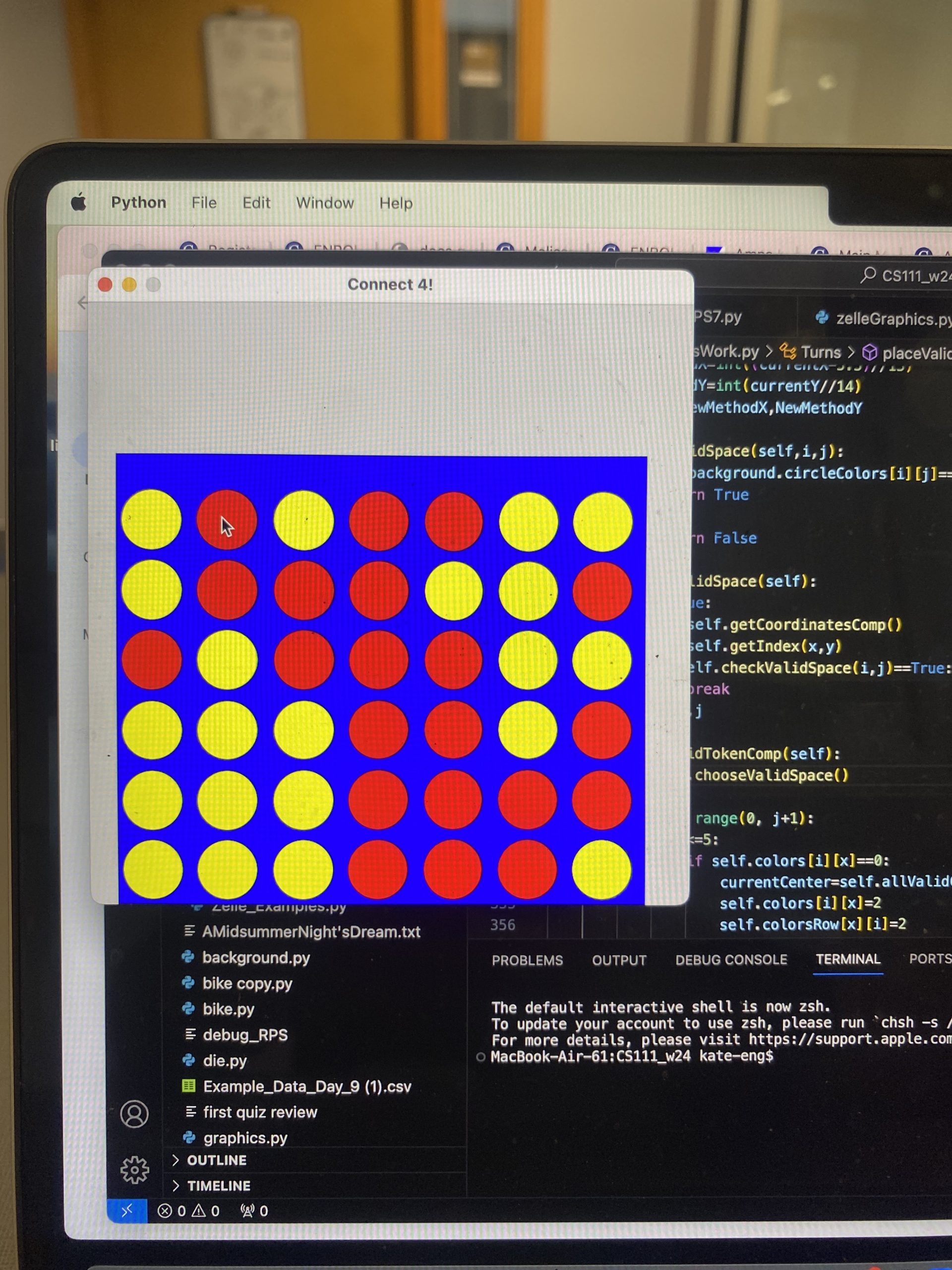 A game of connect four in front of some code