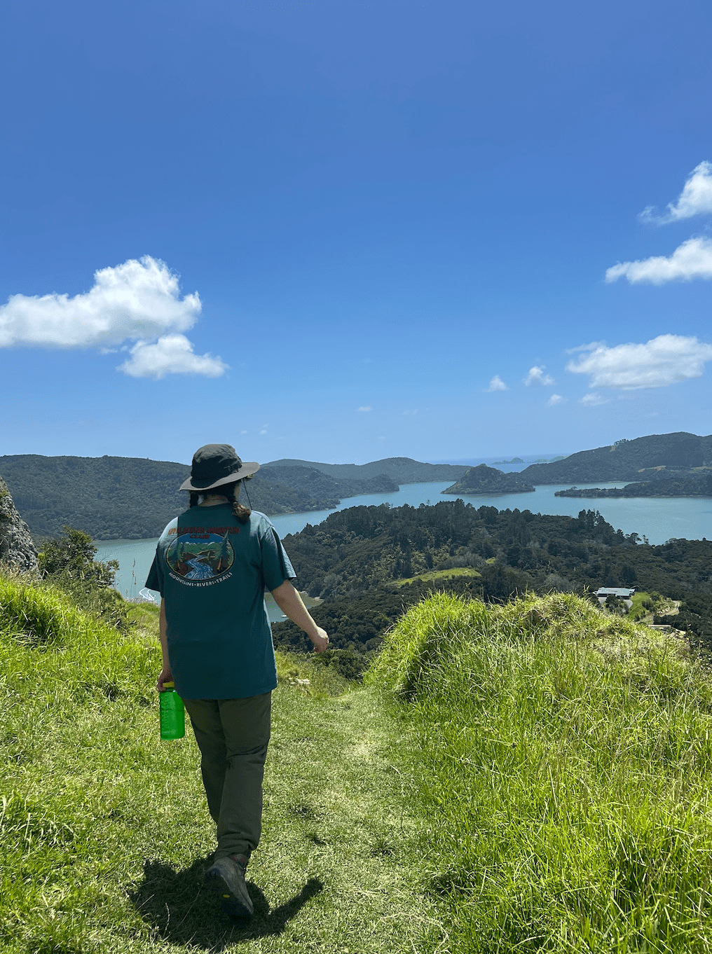 A person hikes in green grass
