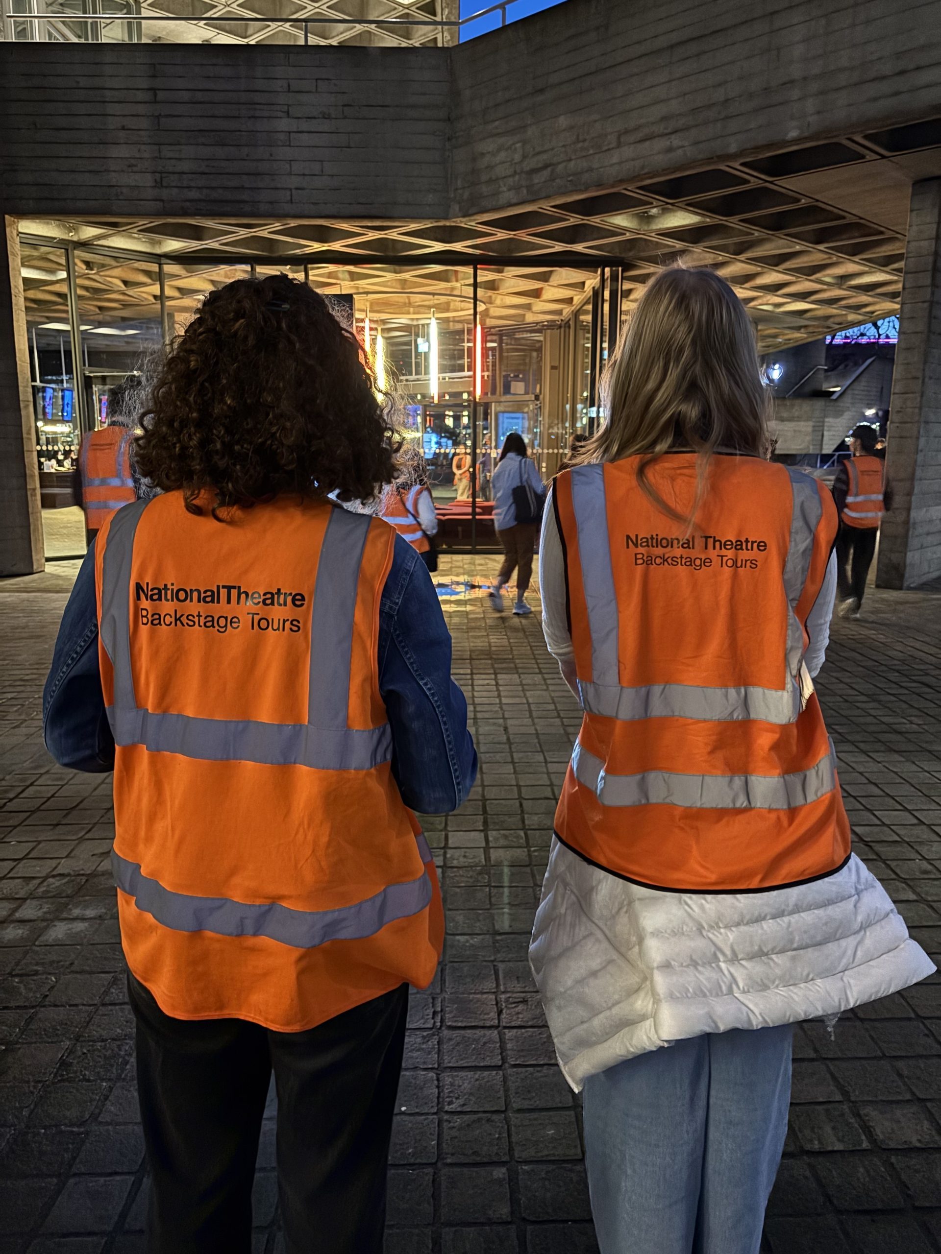 Two girls with vests that say "Backstage Tour"