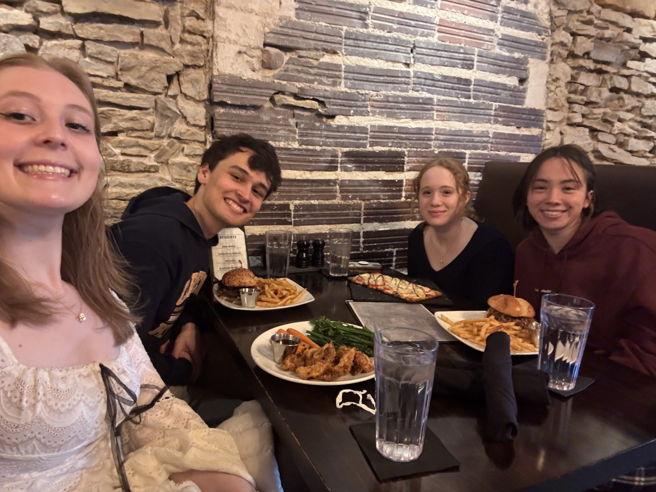 Four people smiling at a dinner table