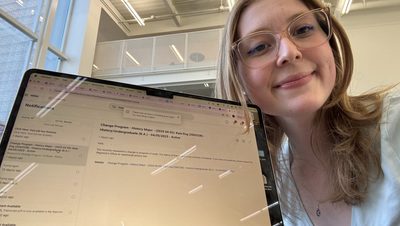 A girl smiling in front of a computer screen